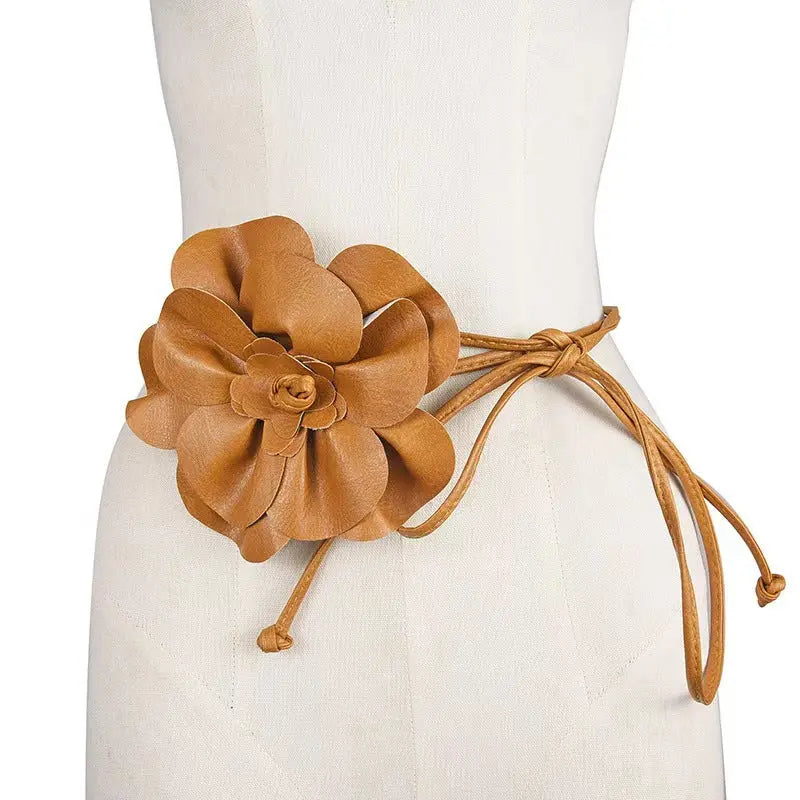 Decorative flower detail on a women's adjustable PU belt for added elegance.