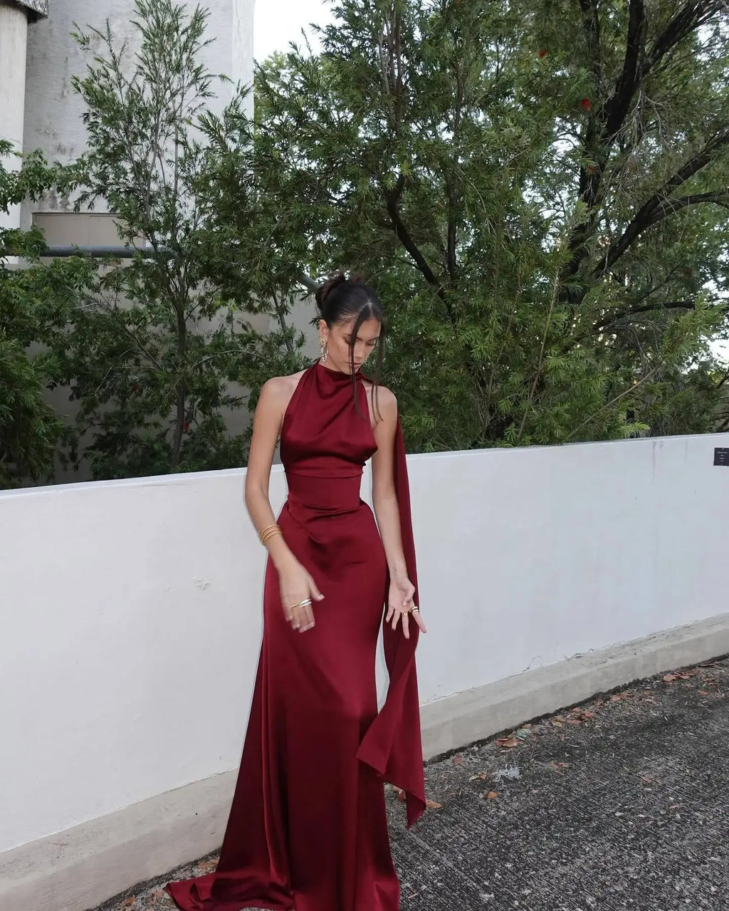 Dramatic mermaid tail detail on a burgundy satin dress for a captivating look.