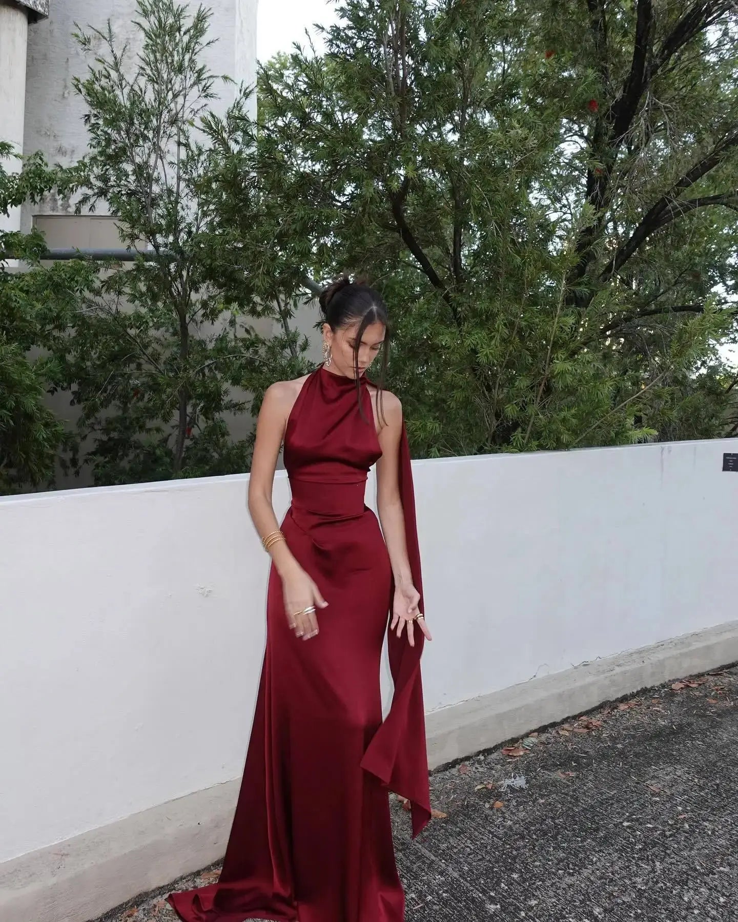 Dramatic mermaid tail detail on a burgundy satin dress for a captivating look.