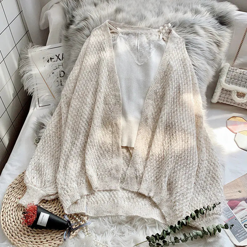 Flat lay of the Breeze Whisper Cardigan with accessories, demonstrating effortless style for any occasion.