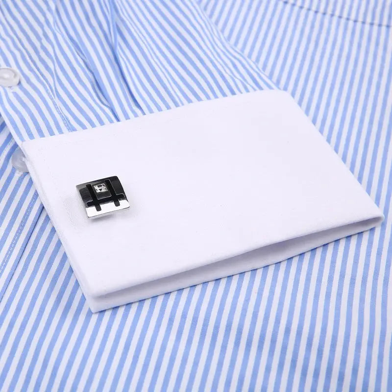 Metal cufflinks included with the striped dress shirt, showcasing sophistication.