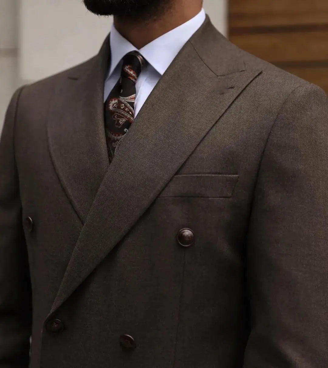 Model wearing a bespoke men's suit, exuding confidence at a formal event.