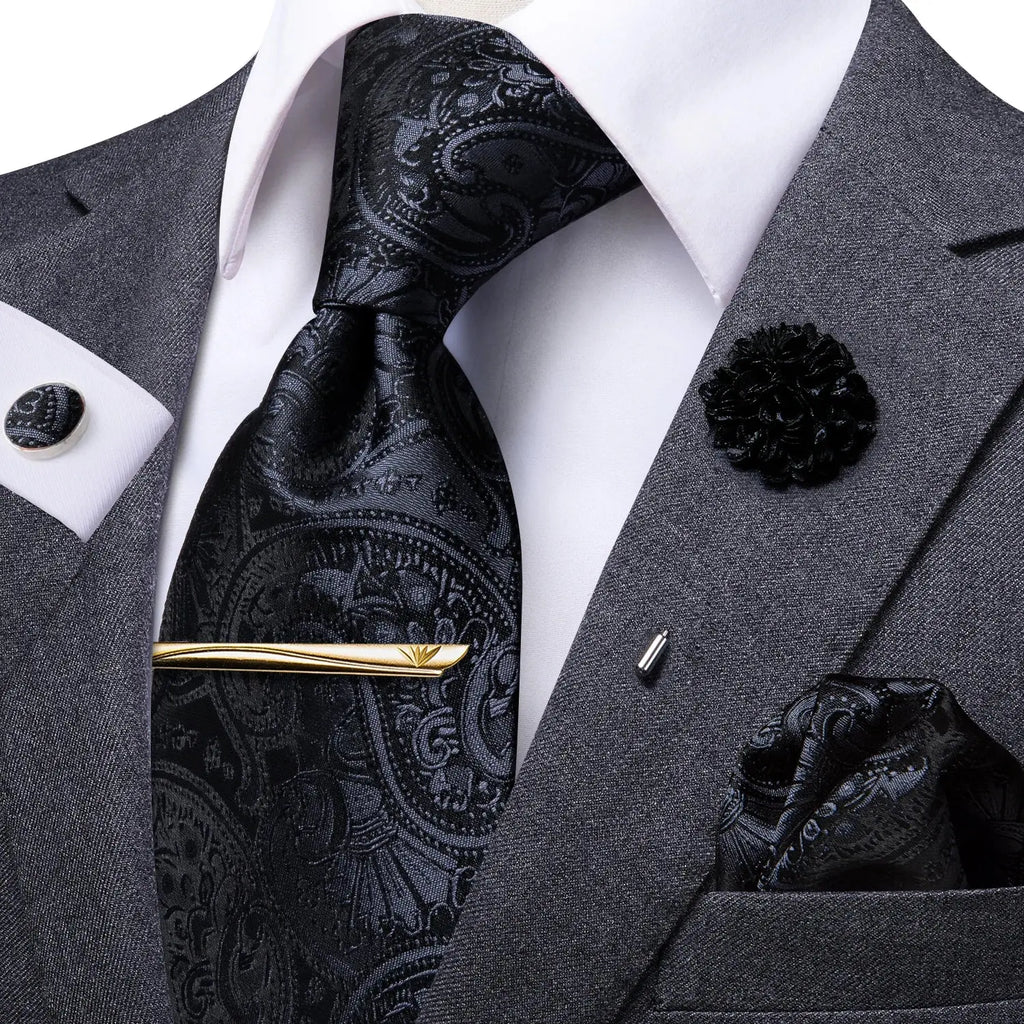 Stylish paisley tie set arranged on a wooden surface.