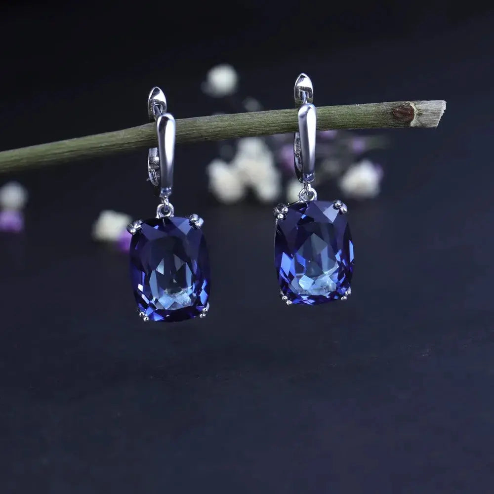Sterling silver drop earrings reflecting candlelight with mystic quartz brilliance.