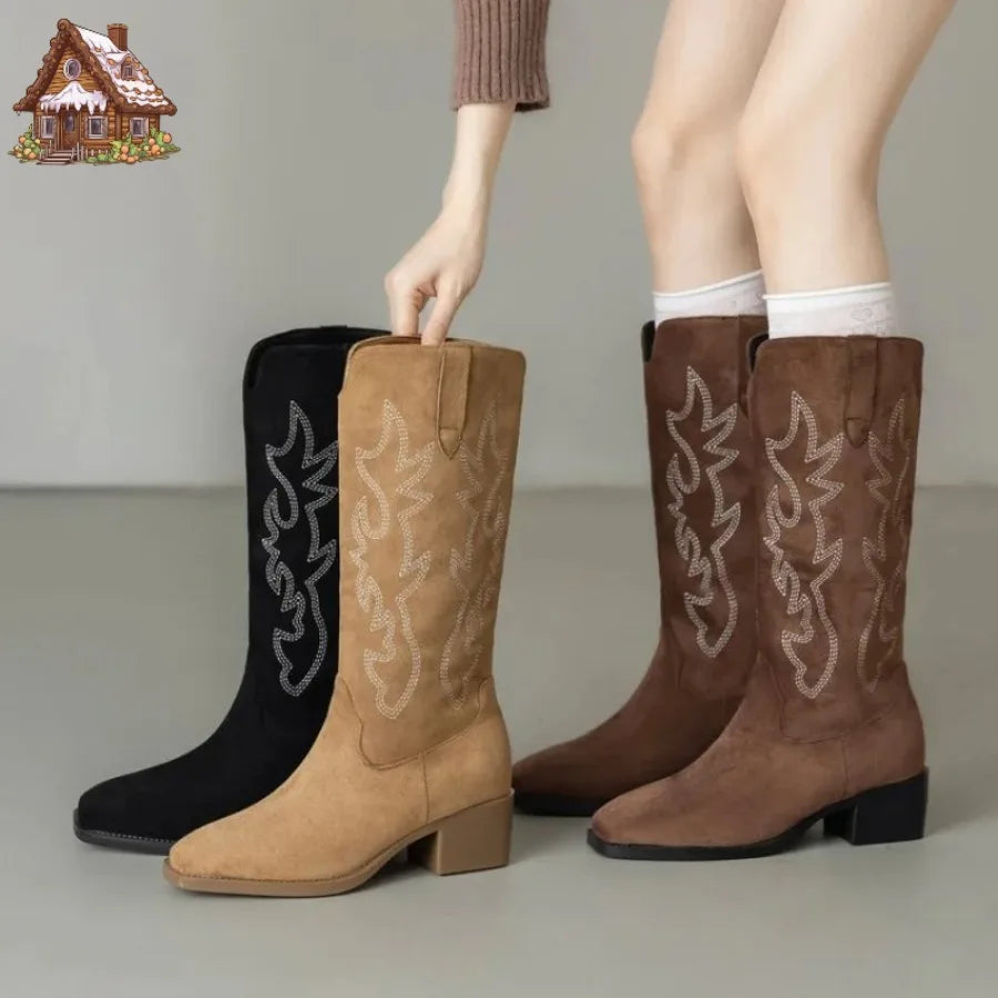 Embroidered leather knee-high cowboy boots with totem design on white background