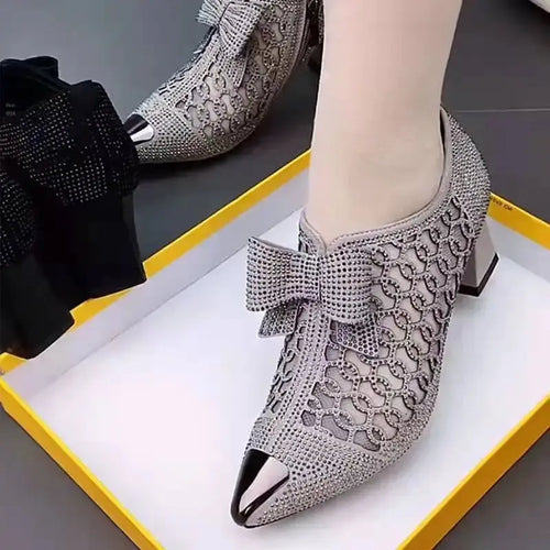 Black bow pumps with sparkling rhinestones, perfect for elegant occasions.