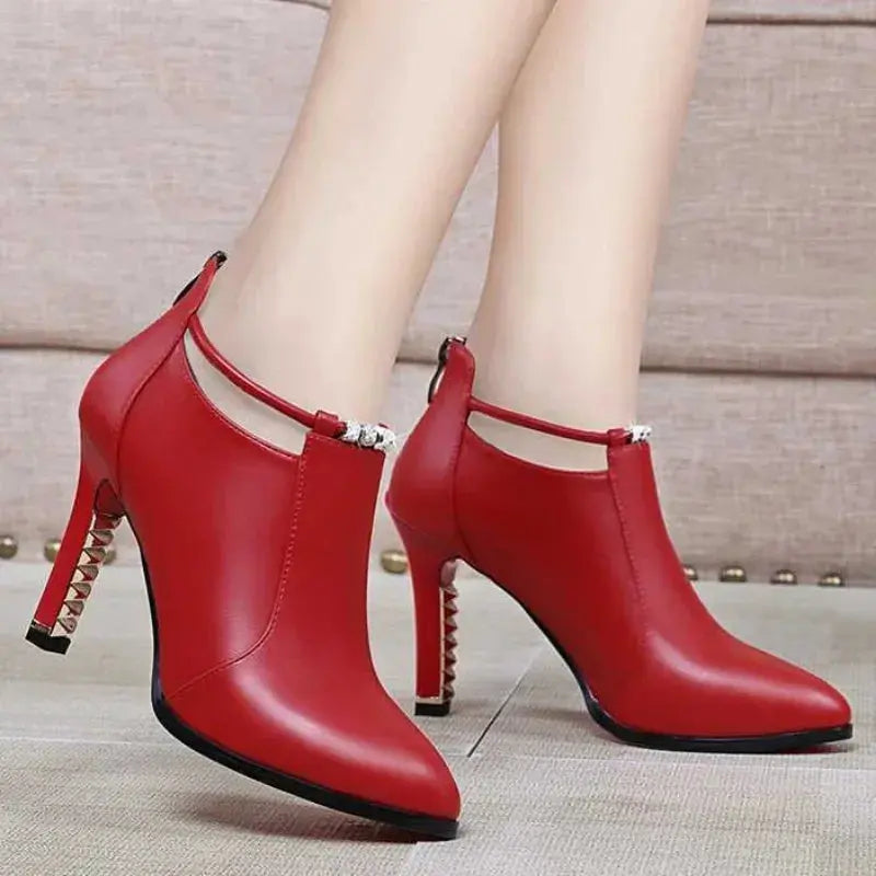Top-down view of the red ankle boots with a robust rubber outsole.