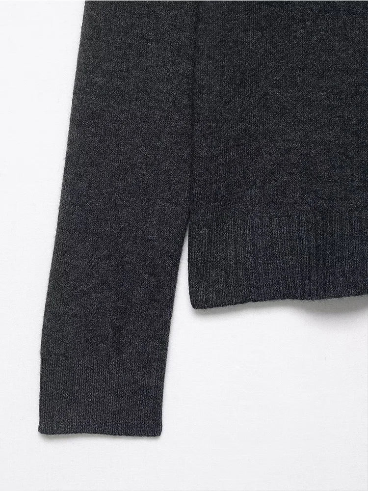 Autumn Whisper Cardigan draped over a chair, illustrating its lightweight and warm fabric.