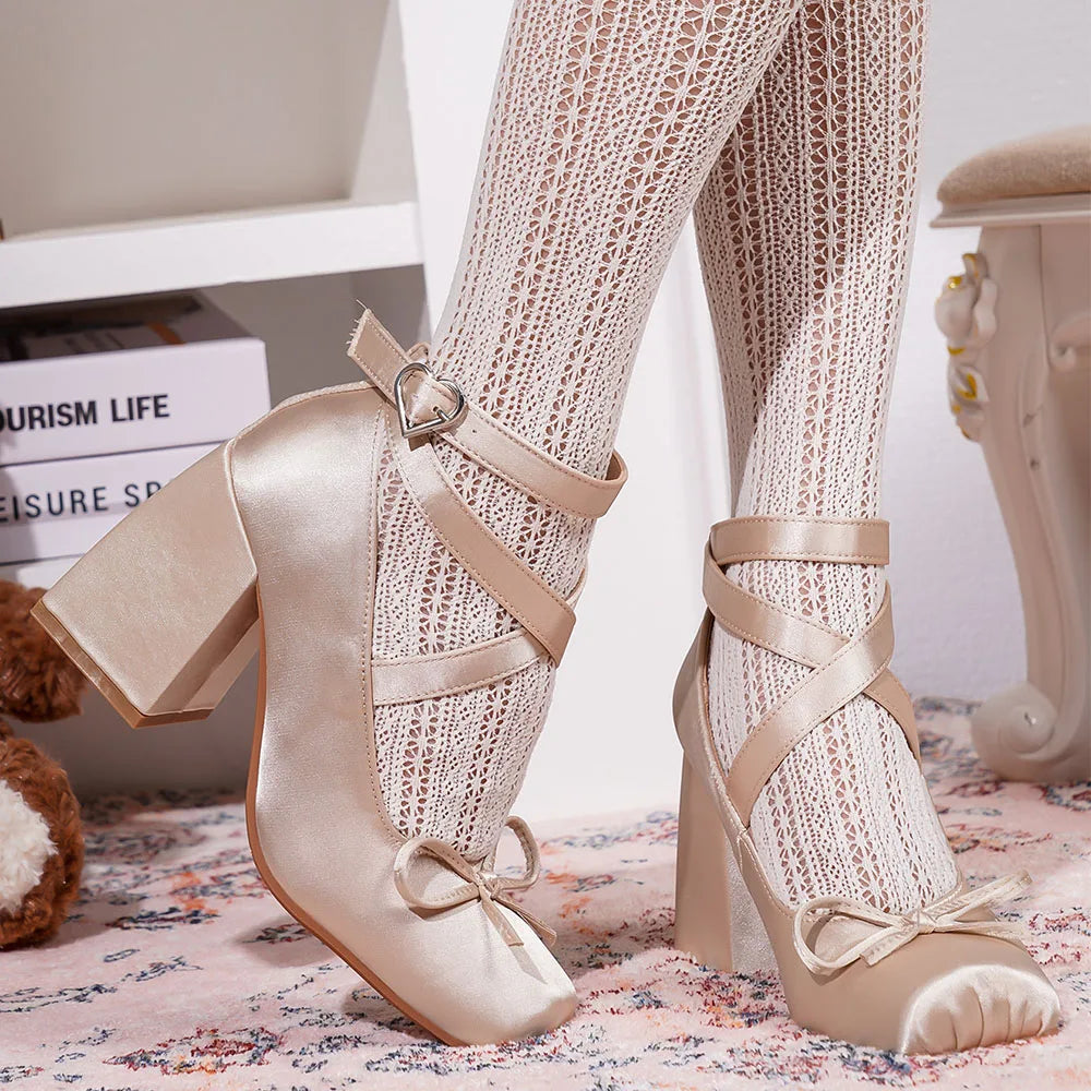 Adjustable buckle strap on blush satin heels for a secure fit.