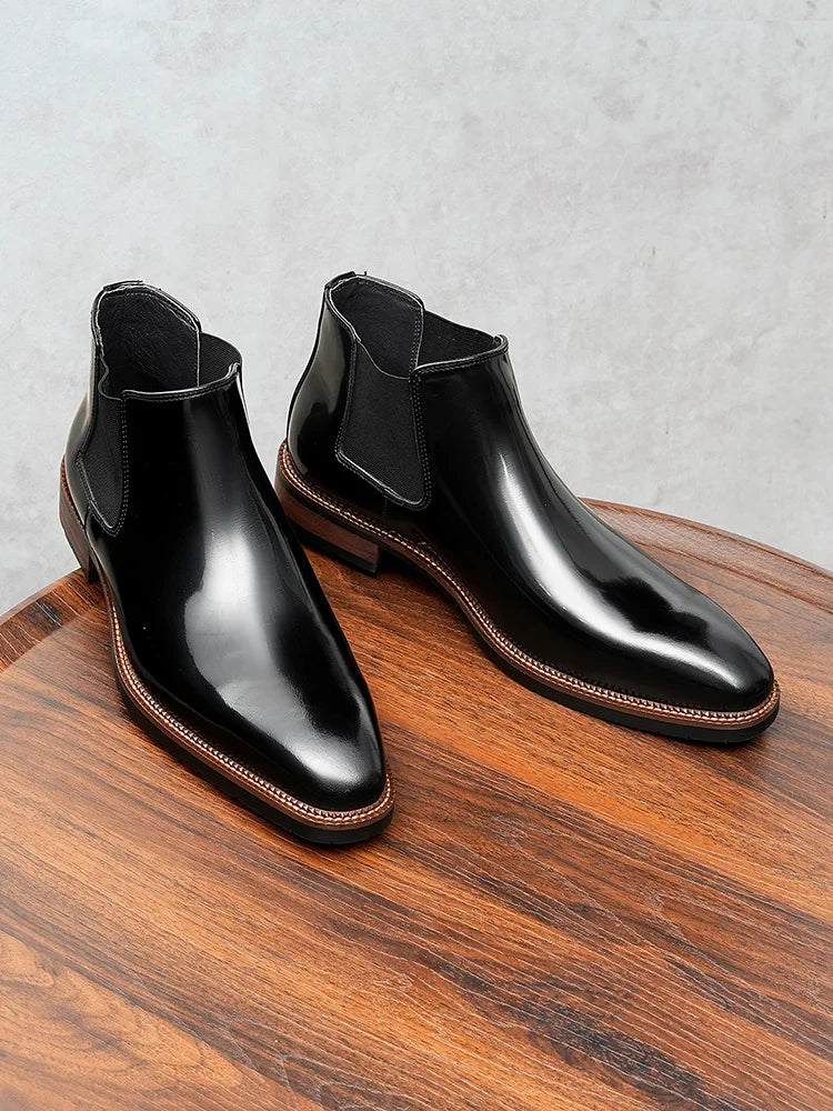 Close-up of glossy leather Chelsea boot showing elastic side gusset and ankle-height silhouette