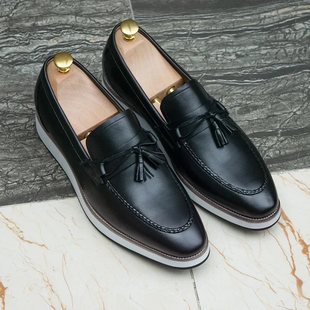 Men's slip-on calfskin loafers in black featuring classic tassels and breathable leather construction