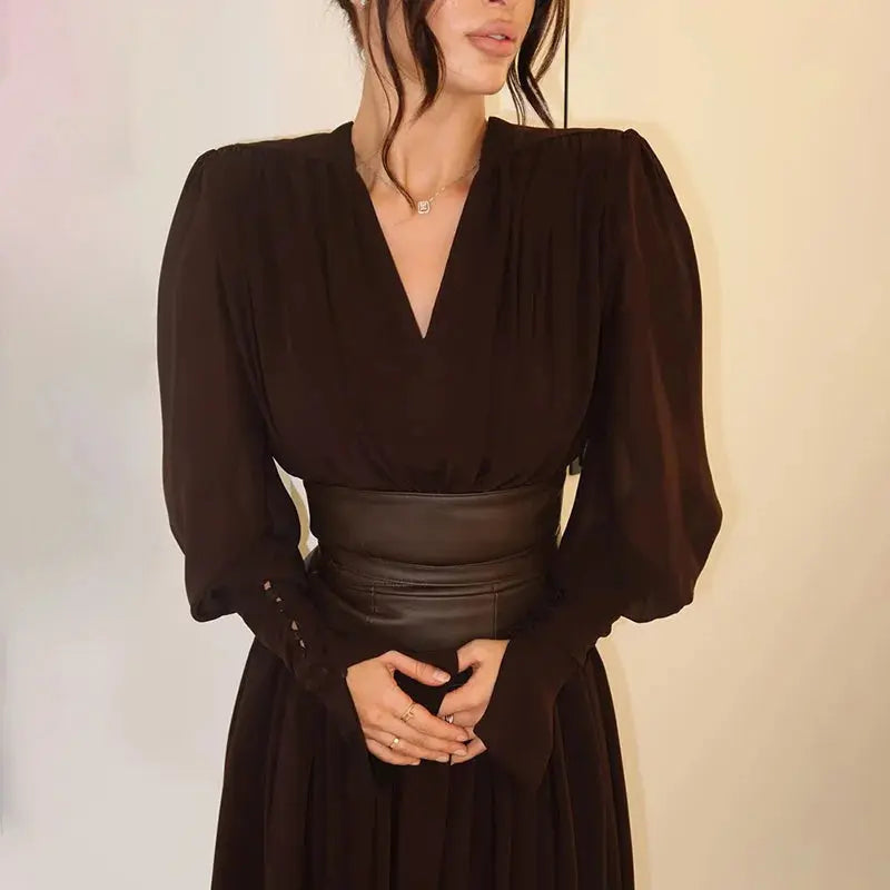 Sleek black maxi dress with deep V-neckline and pleated hem, perfect for evening wear.