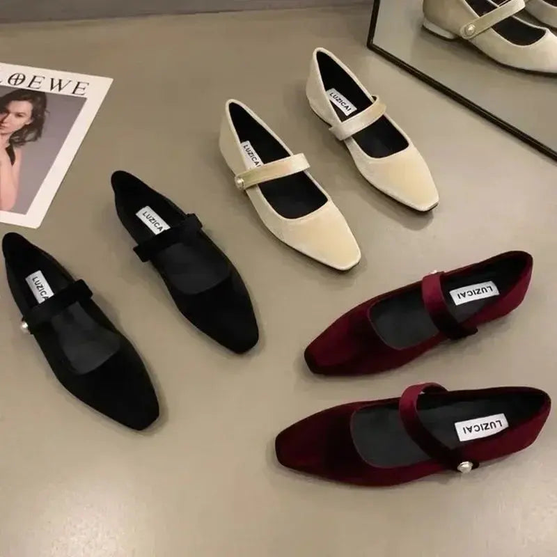 Close-up of the secure buckle strap on stylish faux suede ballet flats.