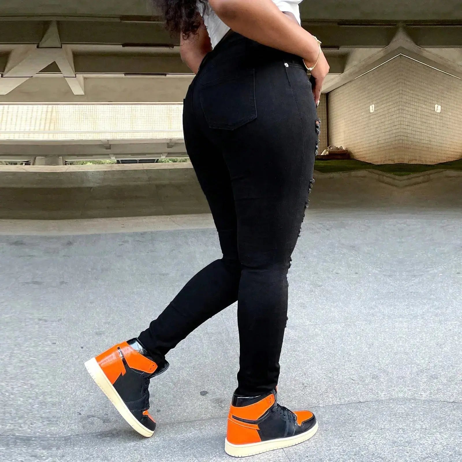 Back view of black stretch jeans with high waist design highlighting curve-hugging cotton-blend construction