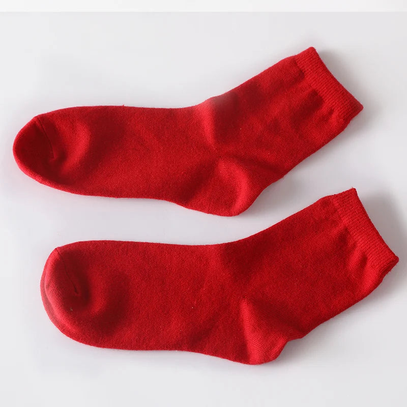 Cozy cashmere socks displayed by a fireplace, emphasizing comfort during chilly evenings.