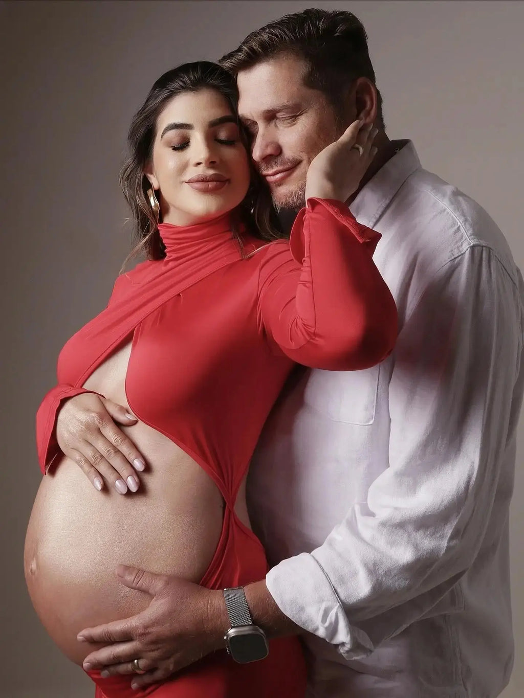Model wearing the Radiant Glow Maternity Gown, cradling her belly under a sunset glow, radiating motherhood.