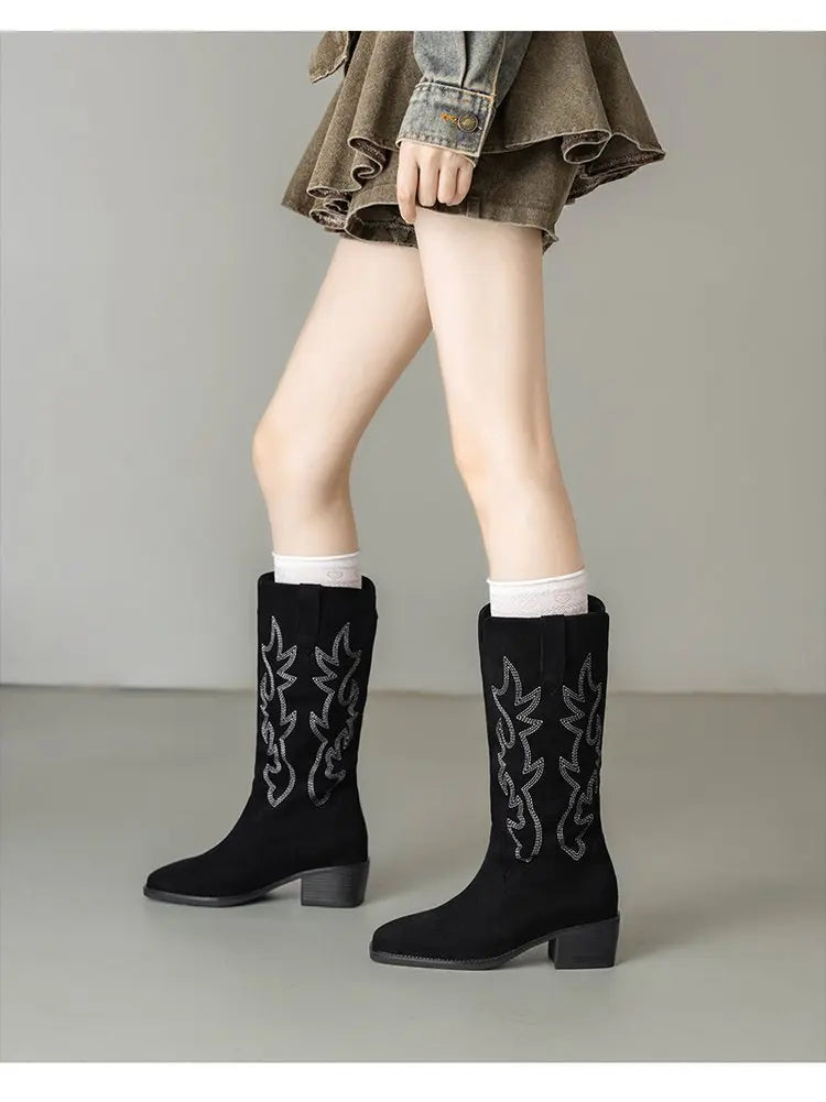 Brown leather cowboy boots with vibrant embroidered totem designs
