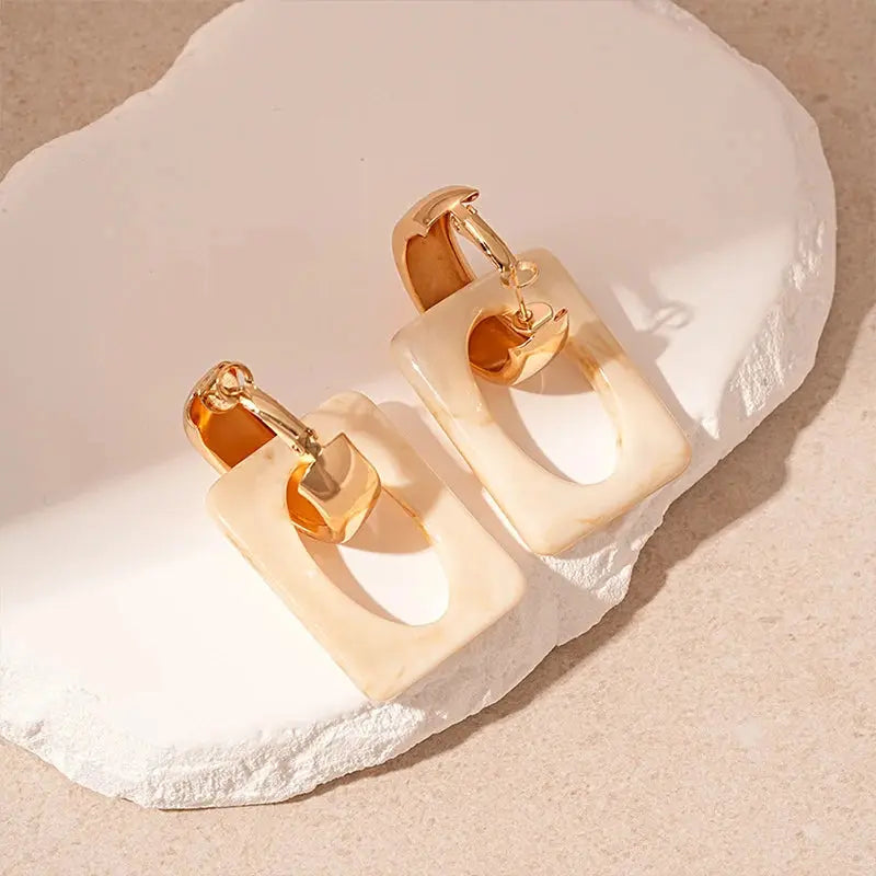 Close-up of lightweight zinc alloy geometric earrings with a smooth resin finish.