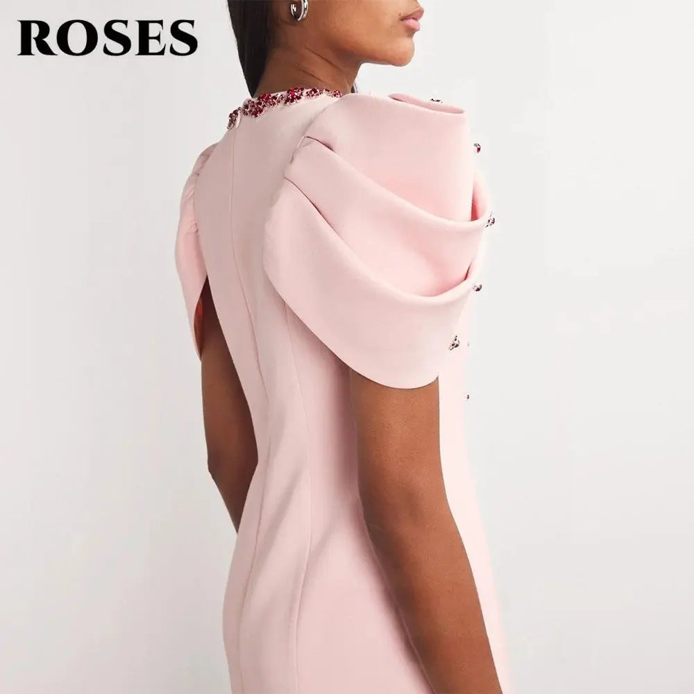 Elegant pink satin dress showcasing delicate pleats and shimmer.