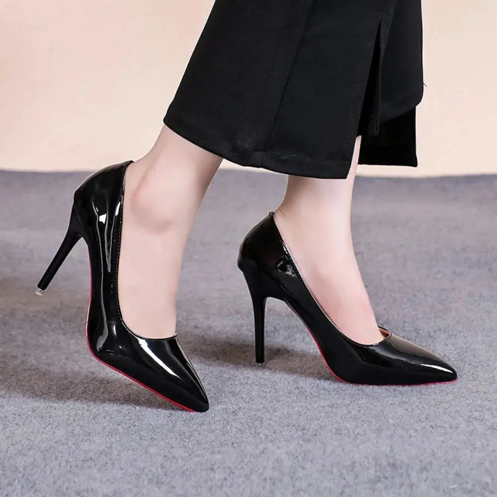 Black pointed heels on a model, exuding confidence in a business attire setting.