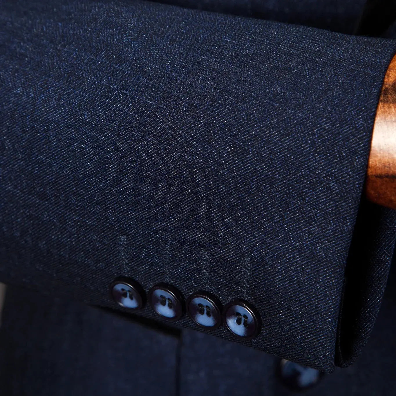 Detail of the single-breasted design on the navy blazer for modern style.