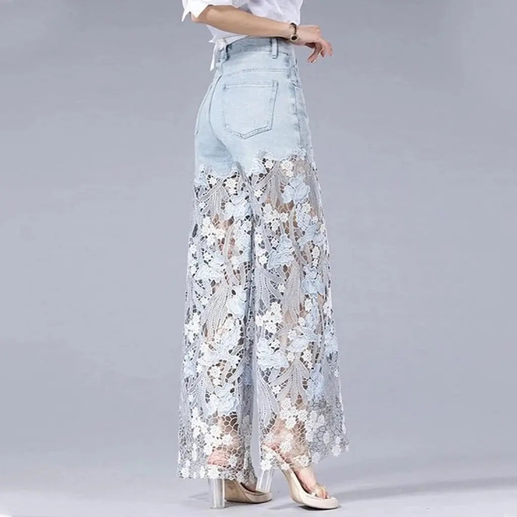 Wide-leg jeans in light denim with lace details and a high waist, perfect for breezy evening strolls.