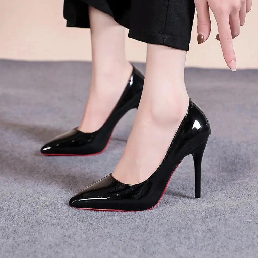 Close-up of black pointed heels showcasing cushioned insoles for comfort.