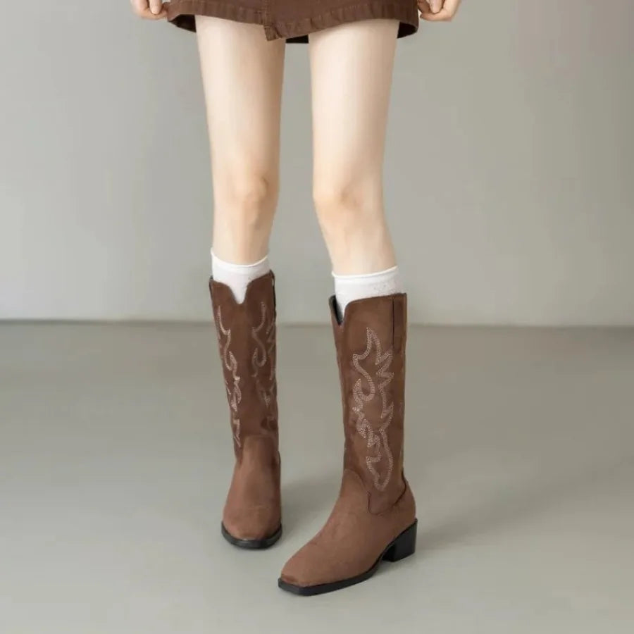 Side view of embroidered leather cowboy boots showing detailed stitching