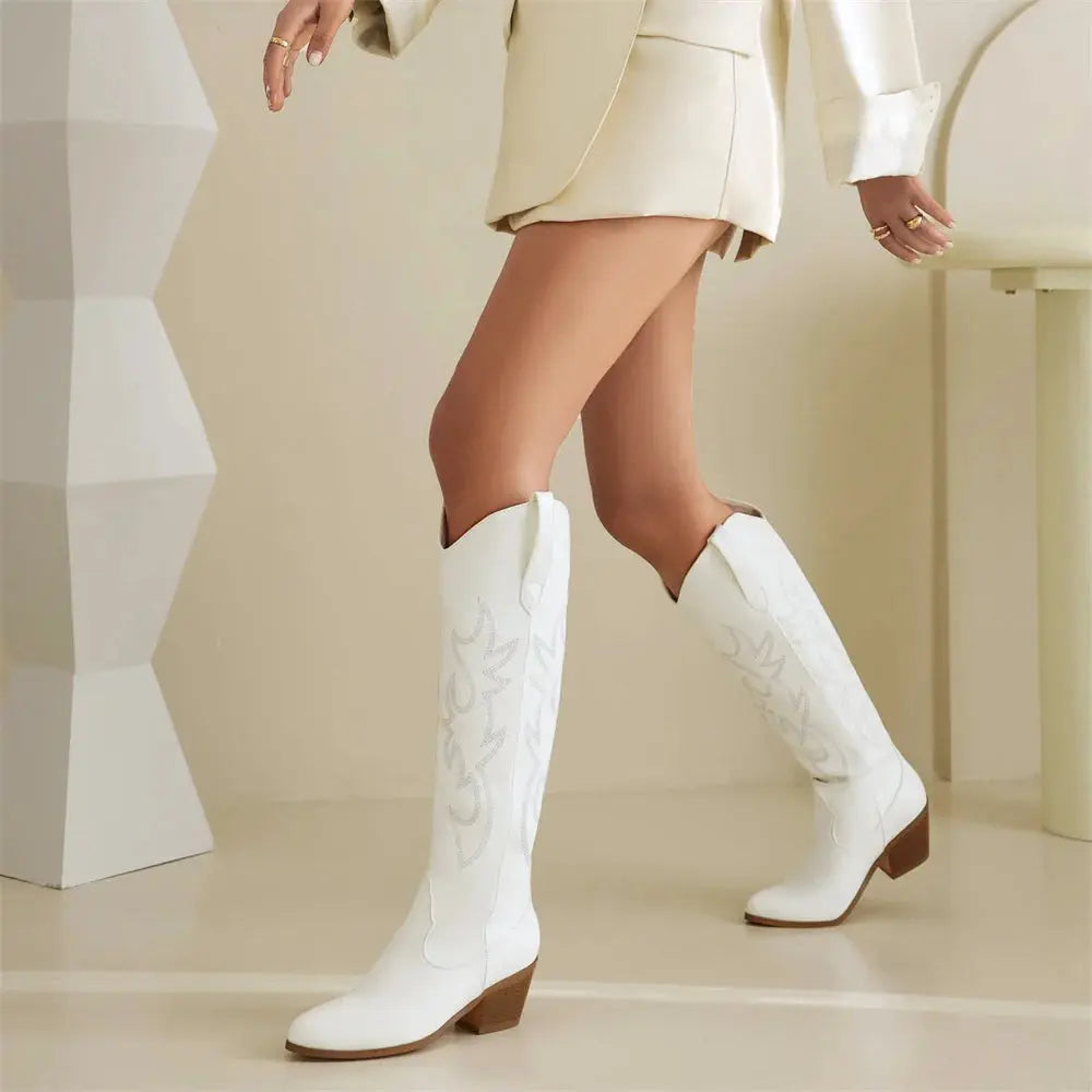 Statement cowboy boots in vegan leather with hand-inspired embroidery, supportive heel, and elongating knee-high design