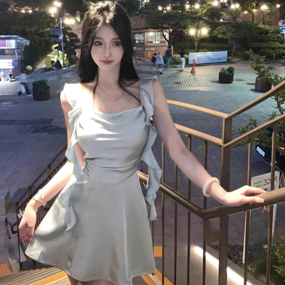 Model wearing Apricot Whisper dress at a summer party, exuding casual chic.