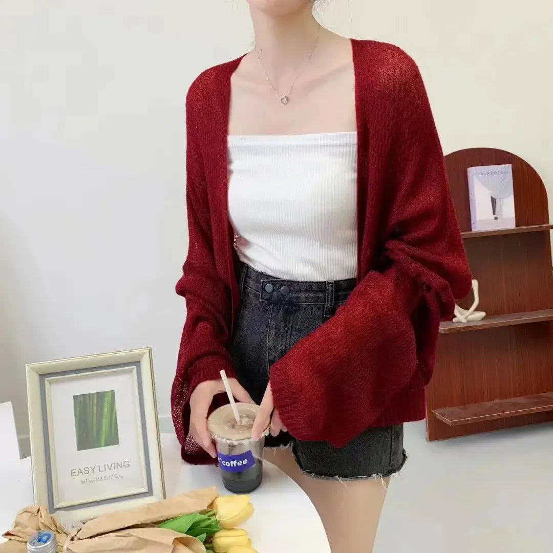 Flat lay of the Summer Breeze Knit Cardigan with accessories, showcasing its versatility for layering.