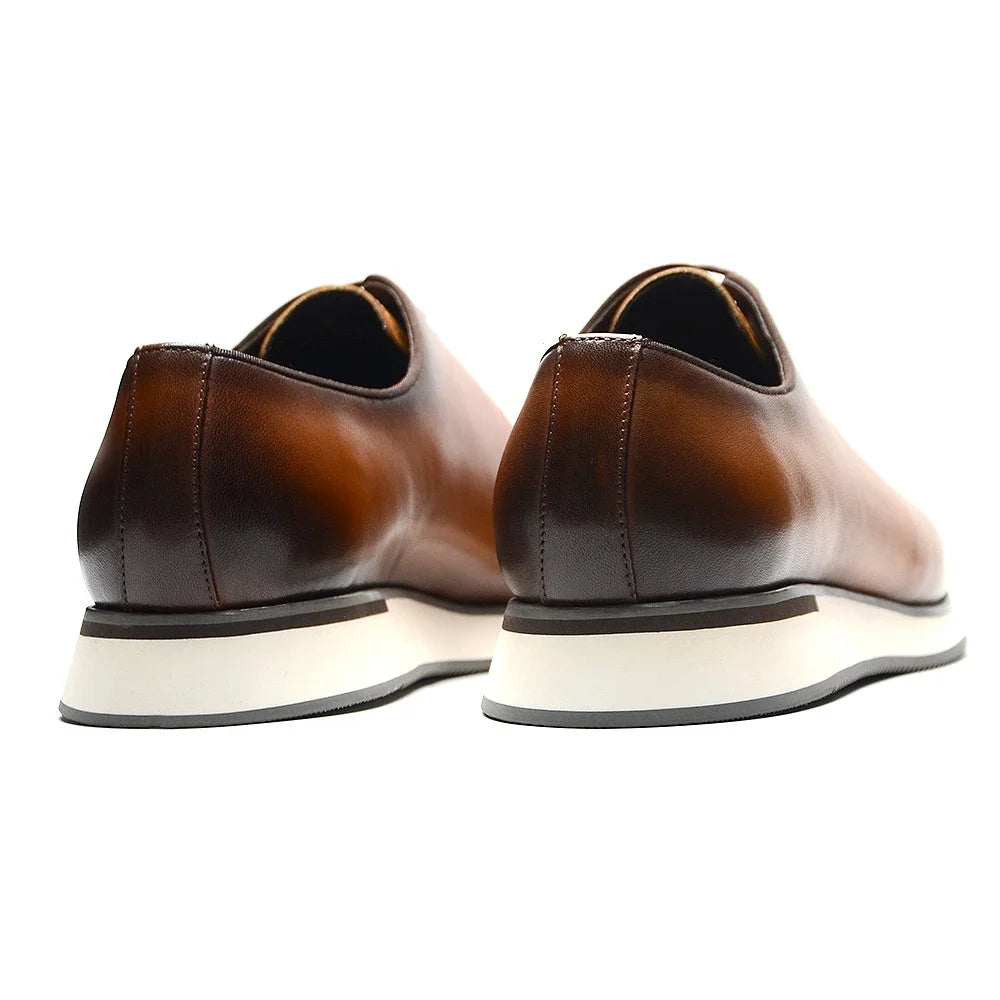 Side view of handmade whole-cut Oxford shoes displaying premium cowhide leather and classic lace-up design