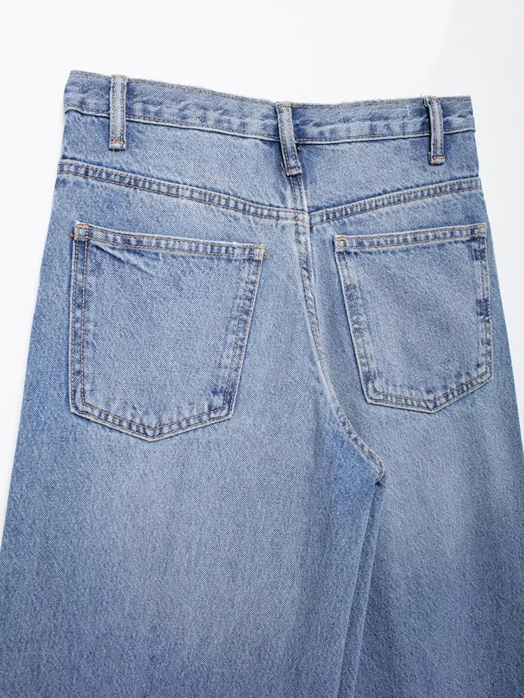 Flat lay of modern vintage asymmetric wide-leg jeans with pockets.