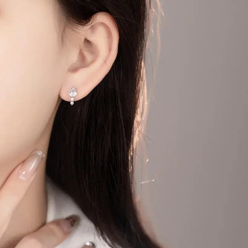 Close-up of zircon stud earrings, highlighting precision-cut stones and elegant water drop shape.