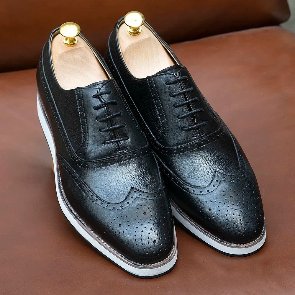 Close-up of wing tip brogue detailing on handcrafted leather Oxford dress shoes