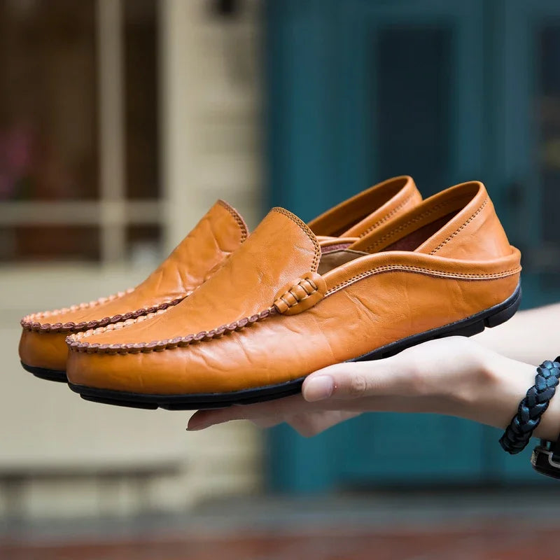 Full view of handcrafted leather loafers on a wooden surface, highlighting their sophisticated design.