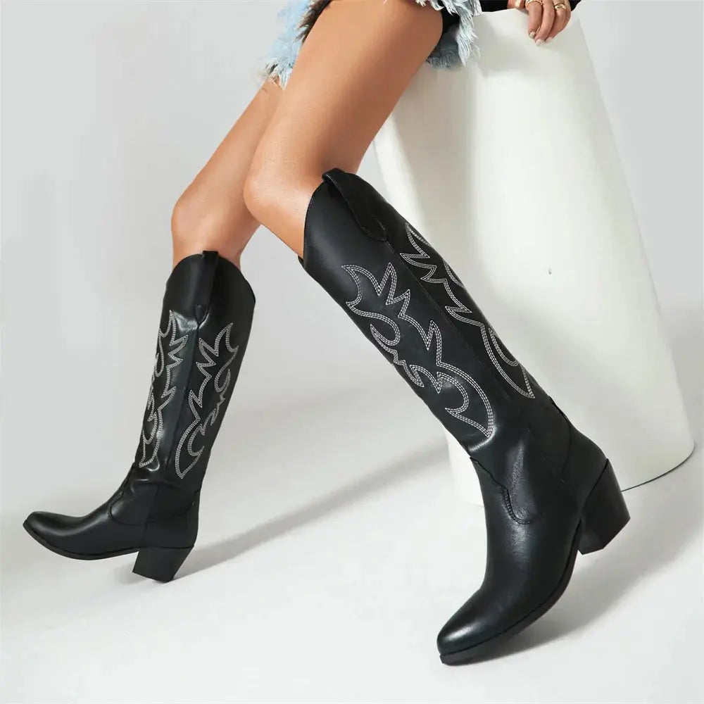 Tan embroidered cowboy boots with knee-high silhouette showcasing artisan-inspired stitching and ethical leather construction