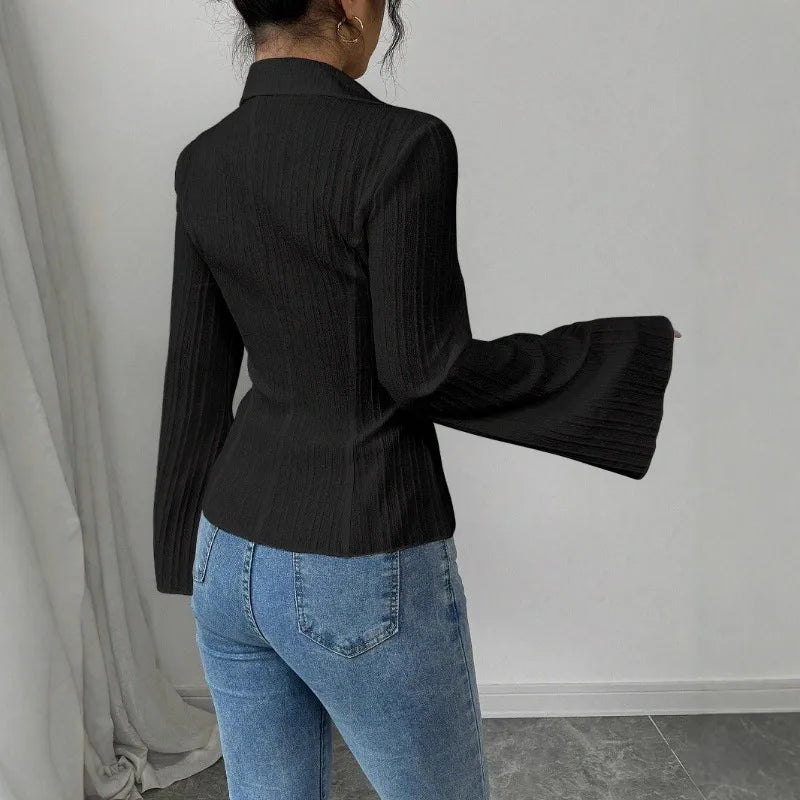 Close-up of statement bell sleeve cuffs on sculpted silhouette peplum blouse showing ribbed texture detail