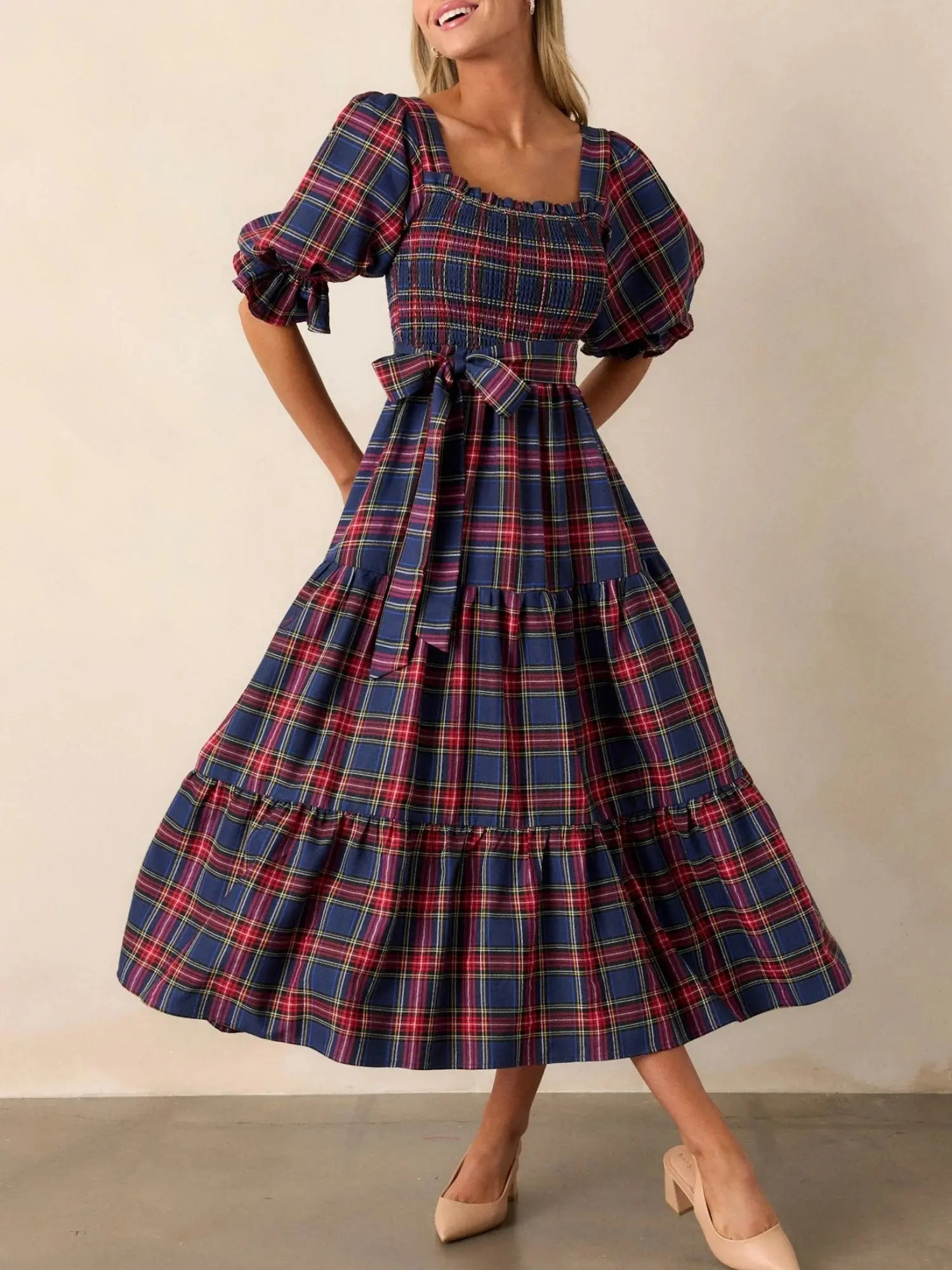 Model wearing the Captivate in Plaid dress, highlighting its elegant mid-calf length.