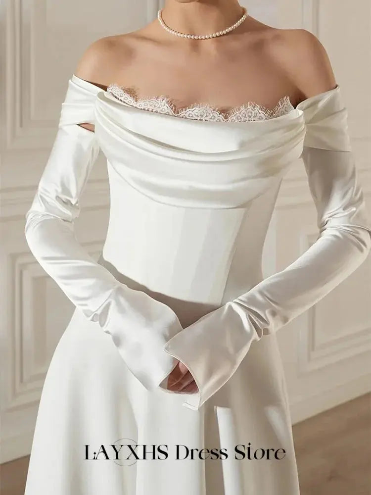 Close-up of lace detailing on the off-the-shoulder neckline of the enchanting wedding dress.