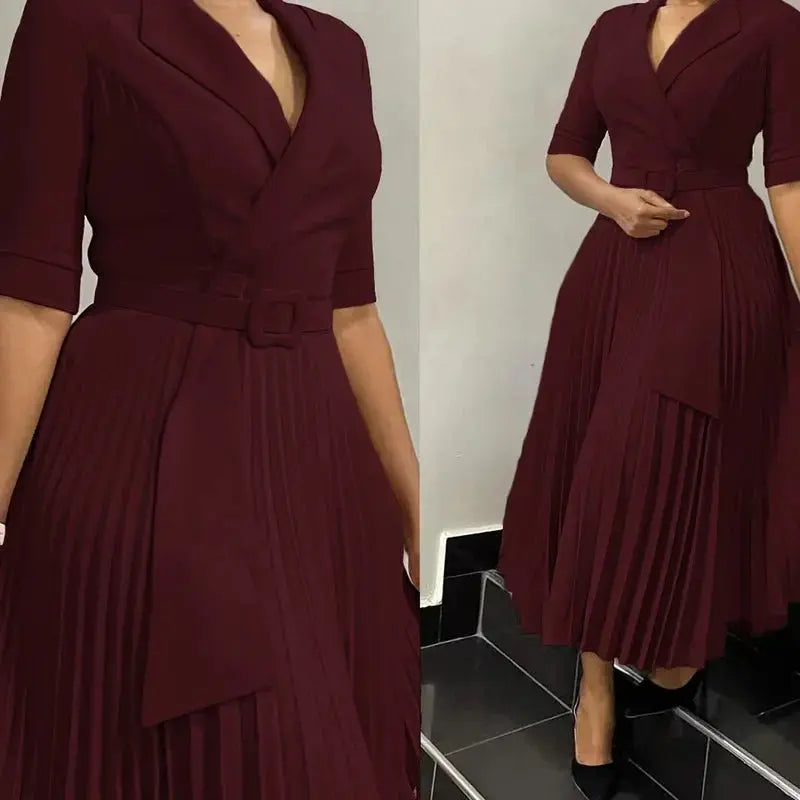 Model wearing the black pleated dress in an office setting, exuding confidence and style.