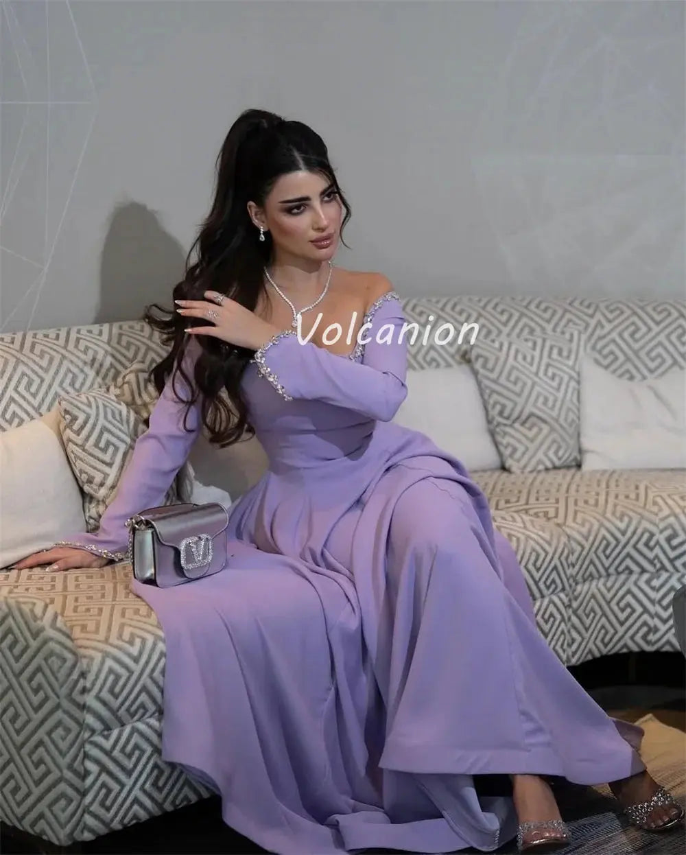 Ruched waist detail of the off-shoulder gown, accentuating the figure with elegant rhinestone embellishments.