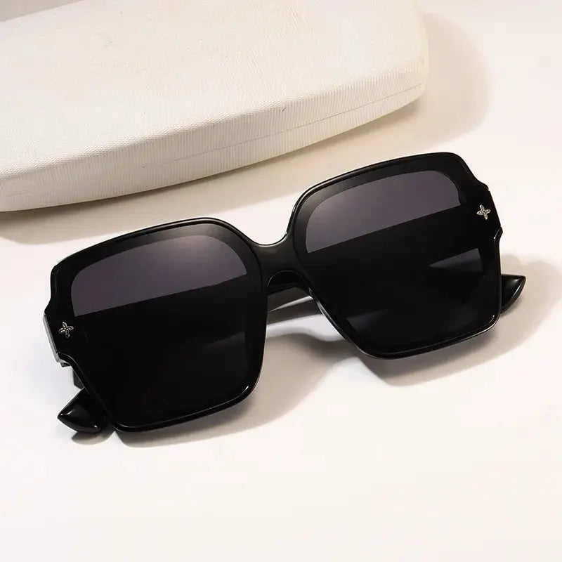 Woman wearing chic UV block sunglasses, showcasing modern square frame.