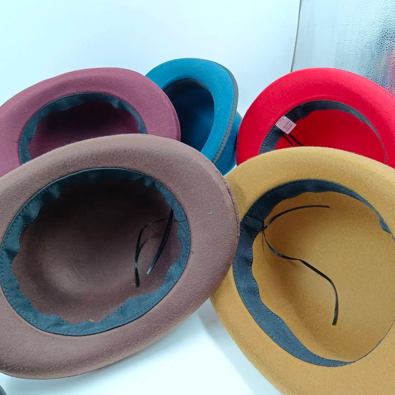 Elegant black fedora showcasing a small flat top and luxurious feather accessory.