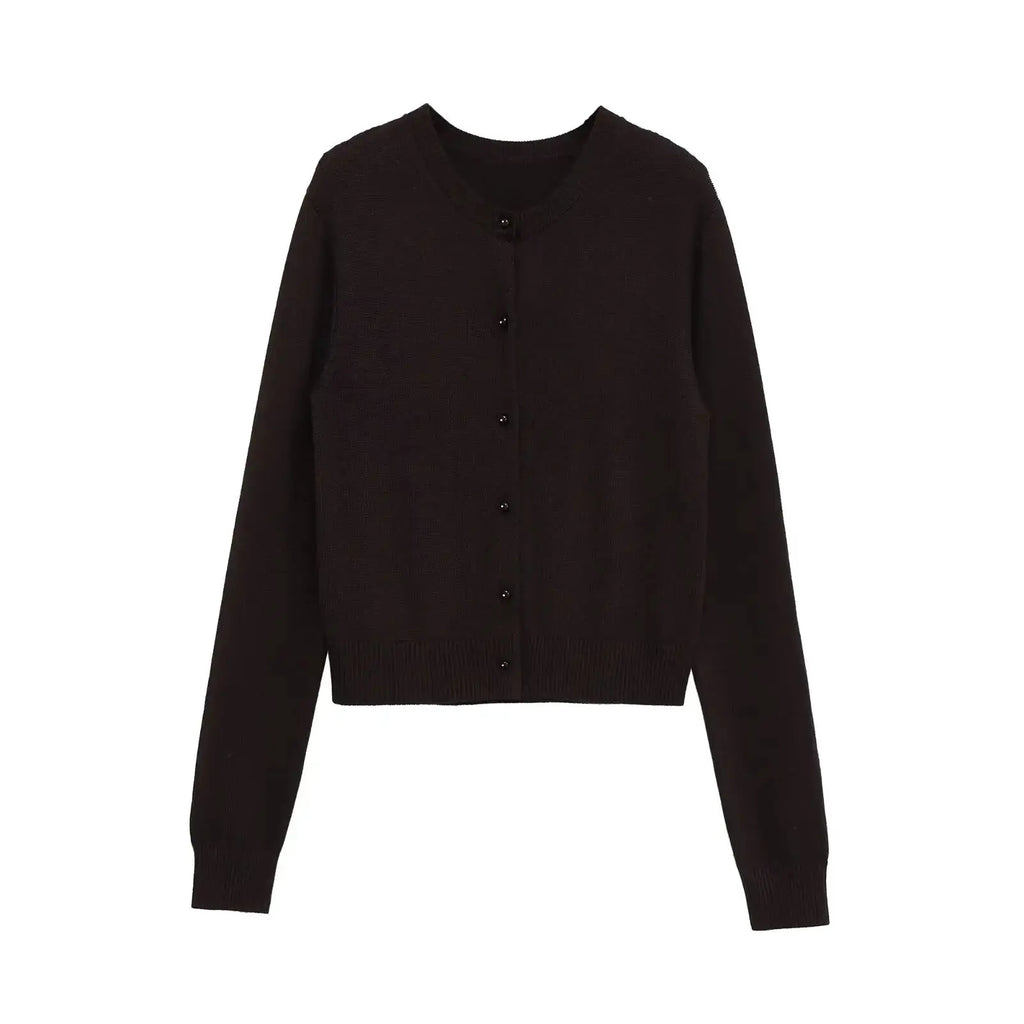 Flat lay of the Autumn Whispers cardigan with autumn leaves, emphasizing its seasonal appeal and warmth.