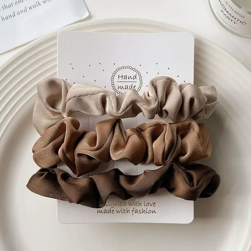 Smooth satin scrunchies gliding through hair without tugging or pulling