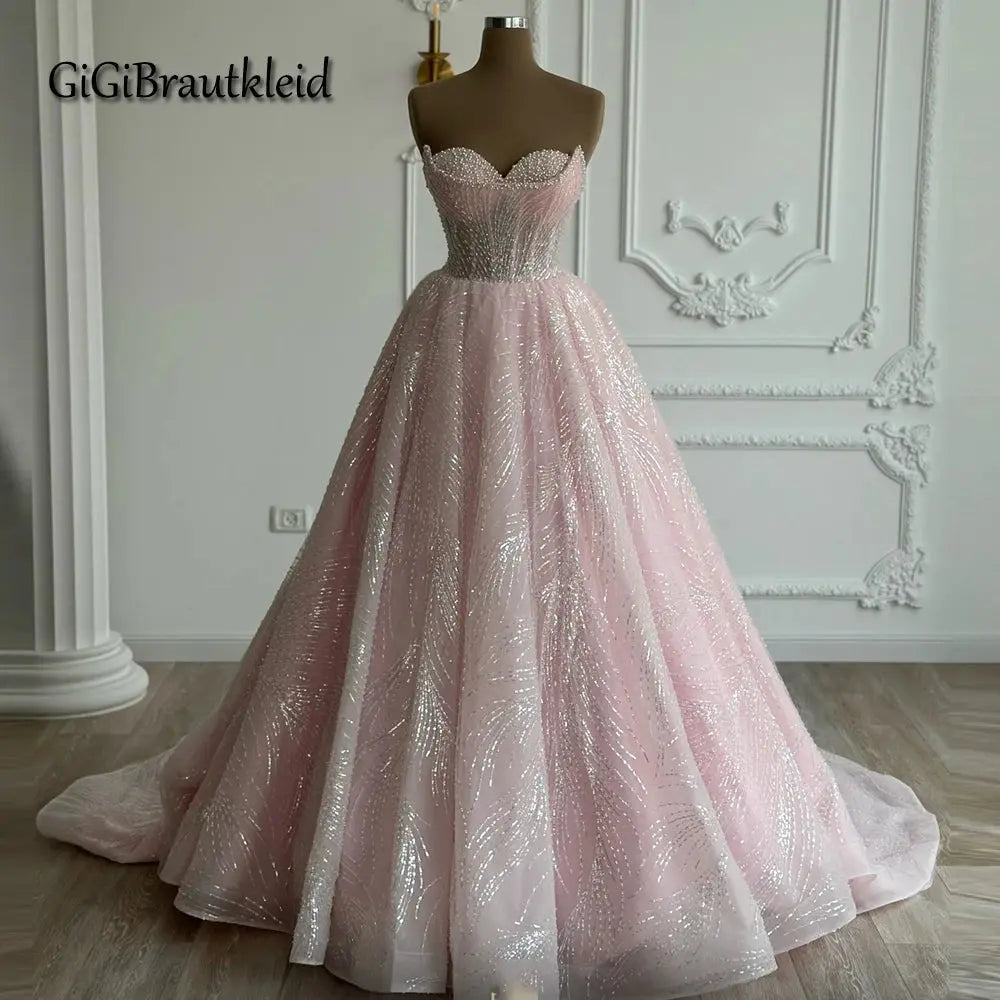 Elegant floor-length gown with hand-sewn pearls and soft tulle, featuring a sweetheart neckline and adjustable lace-up back.