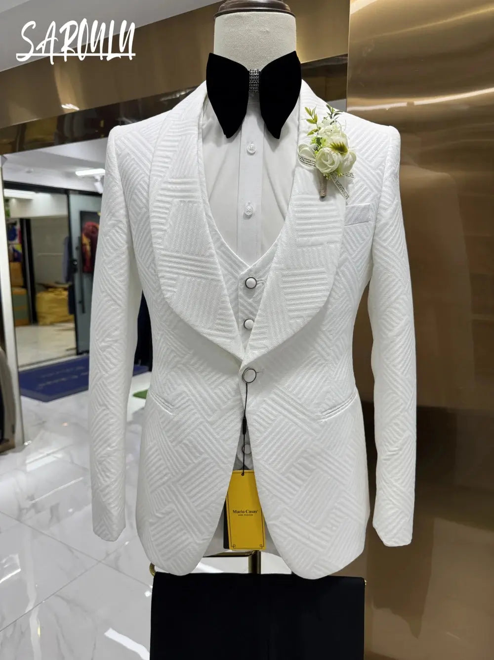 White jacquard three-piece suit featuring a sleek jacket and tailored trousers.