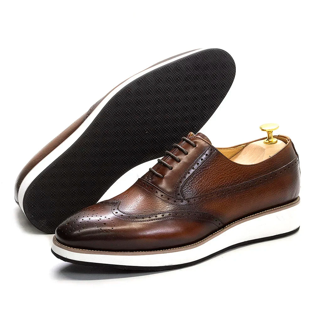 Handmade leather Oxford shoes with classic wing tip detail in black and brown on white background