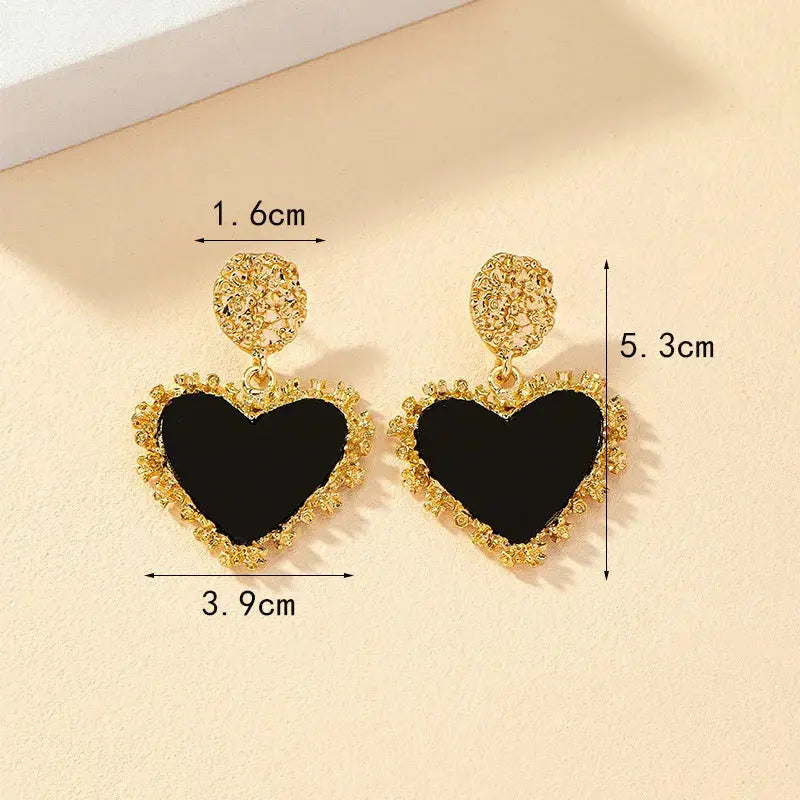 Close-up of Heartfelt Whispers Dangle Earrings showcasing their intricate heart shape and light-catching detail.